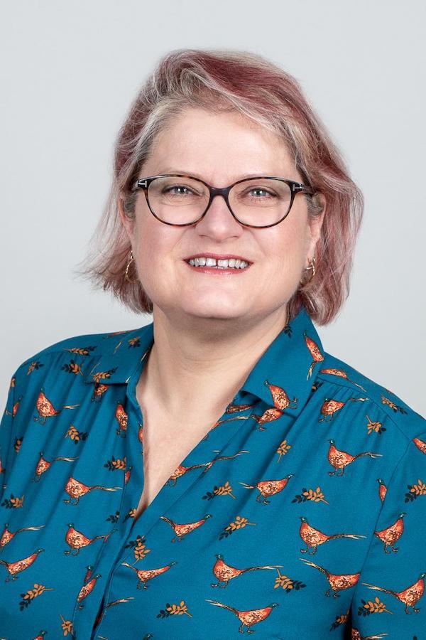 A headshot of Anne Barrett smiling at the camera.